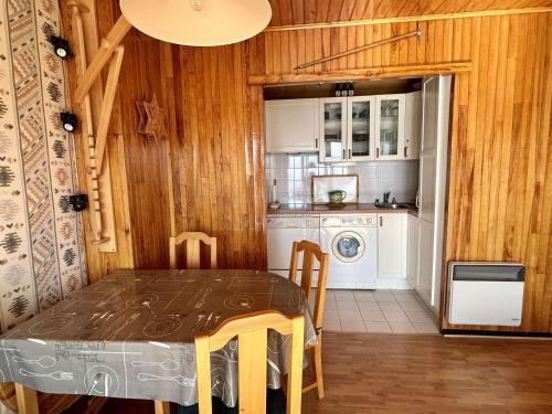 une salle à manger avec une table et une cuisine dans l'établissement Appartement cosy 2 pièces 4 pers, proche télésiège, retour skis aux pieds - Vieil Alpe - FR-1-405-338, à Huez