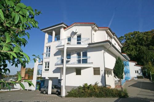 a white building with balconies on a street at Residenz Binz - FeWo 16 in Binz