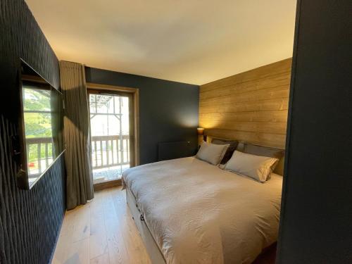 a bedroom with a large bed and a window at Méribel Mottaret - Appartement 3 chambres, 6 pers, parking, terrasse, skis aux pieds - FR-1-613-105 in Les Allues