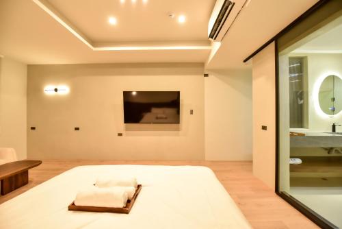 a living room with a bed and a tv at Two Couples Leisure Art Motel in Tainan