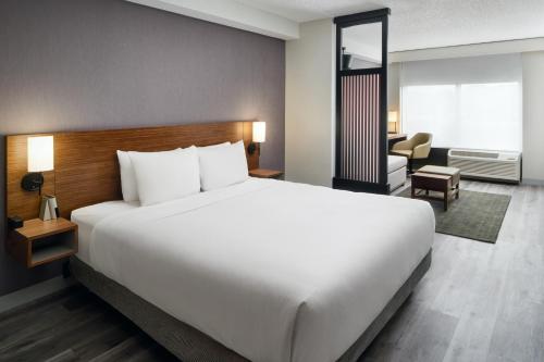 Una gran cama blanca en una habitación de hotel. en Hyatt Place Greensboro, en Greensboro