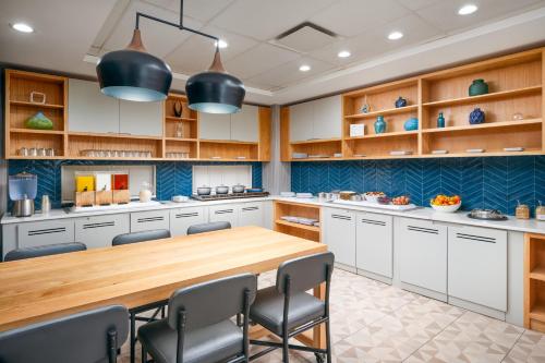 a large kitchen with a wooden table and chairs at Hyatt Place Greensboro in Greensboro
