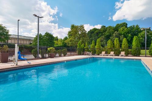 a swimming pool with blue water in a building at Hyatt Place Greensboro in Greensboro