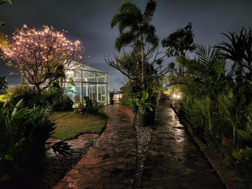 a garden with palm trees and a greenhouse at night at Bansabai Hostelling International in Bangkok
