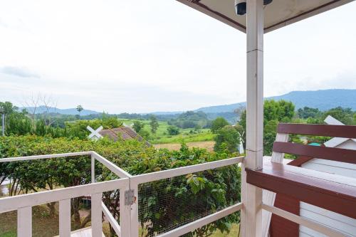 a porch with a bench looking out at a vineyard at เขาค้อออฟเลิฟ in Khao Kho