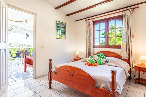 1 dormitorio con 1 cama y balcón en Bungalow de 2 chambres a Bouillante a 70 m de la plage avec vue sur la mer piscine partagee et jardin clos, en Bouillante