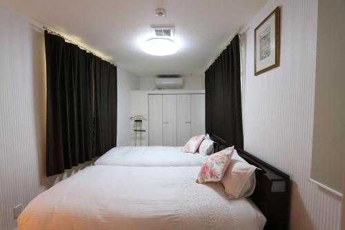 dos camas sentadas una al lado de la otra en un dormitorio en 東京昭島迎賓館A, en Akishima