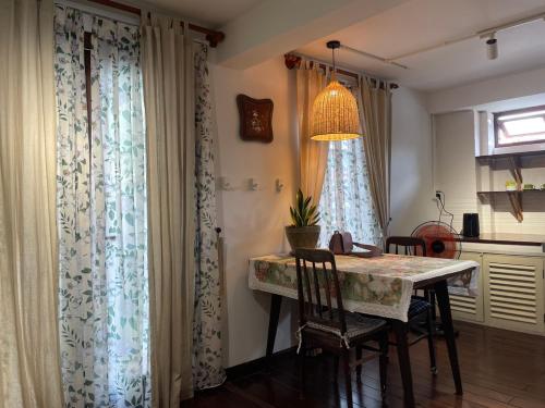 a dining room with a table and chairs and curtains at Mận Đào Villa in Ho Chi Minh City