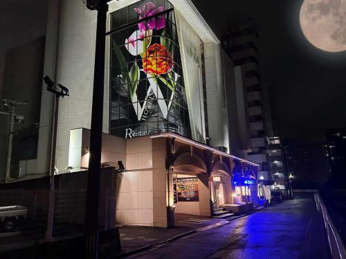 ein Gebäude mit einem Buntglasfenster an einer Straße in der Unterkunft SKY Windy Adult Only Love Hotel in Kitakyūshū