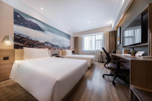 a hotel room with two beds and a desk at Atour Hotel Lanzhou Xiguan Zhengning Road in Lanzhou