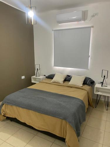 1 dormitorio con 1 cama grande y 2 mesitas de noche en Departamento Cristo del Portezuelo I in 