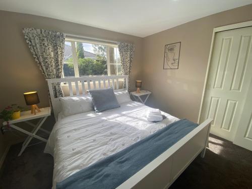 Schlafzimmer mit einem großen Bett und einem Fenster in der Unterkunft The Ground Floor Guest Suite in Dunedin
