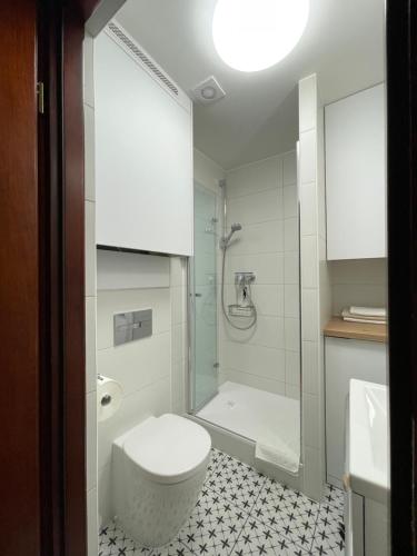 a bathroom with a white toilet and a shower at Apartament Lubelski Zamkowy in Lublin