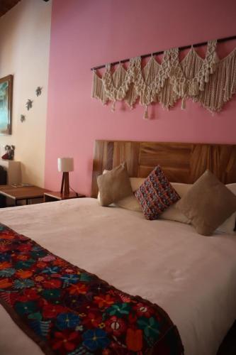 a bedroom with a large white bed with pink walls at Hotel Boutique Sol y Luna SPA in Ajijic