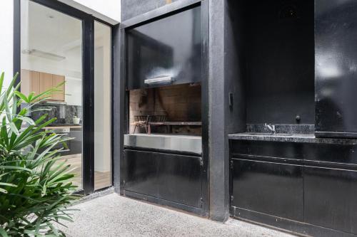 una cocina con puertas negras y fregadero en Fliphaus Honduras 5700 - Lux 5 Bd Pool & Bbq en Buenos Aires