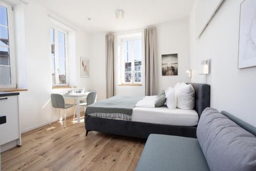 a bedroom with a bed and a couch and a table at DWELLSTAY - Zuse Höfe Bad Hersfeld in Bad Hersfeld