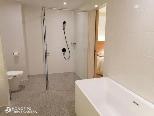 a bathroom with a shower and a toilet at Crystal Crown Hotel Harbour View, Port Klang in Klang