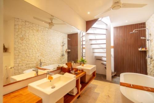 a bathroom with two sinks and a staircase at The Jimbaran Villa by Ini Vie Hospitality in Jimbaran