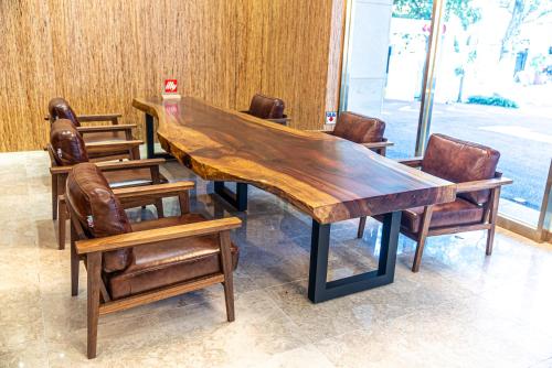 a wooden table and chairs in a room at Hotel The Grang Seogwipo in Seogwipo