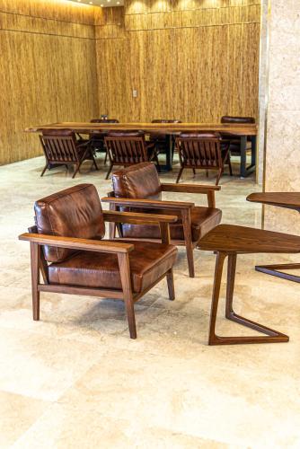 a group of wooden chairs and tables in a room at Hotel The Grang Seogwipo in Seogwipo