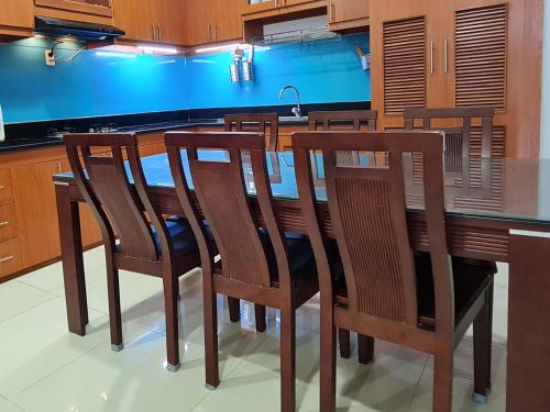 una cocina con sillas de madera y una isla de cocina en Rosemary Homestay, en Vung Tau