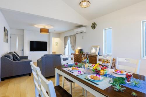 a dining room and living room with a table and chairs at BBQ可能 美ら海水族館まで5分 最大11名宿泊可能　Emerald Side3 in Urasaki
