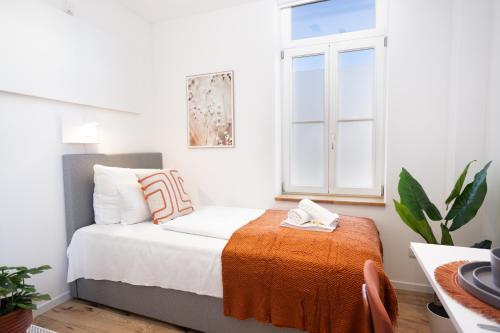 a small bedroom with a bed and a window at DWELLSTAY - Zuse Höfe Bad Hersfeld in Bad Hersfeld