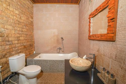 a bathroom with a toilet and a bath tub at Dewata ubud in Ubud