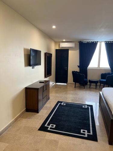 a room with a bed and a tv and a couch at BULAND HEIGHTS in Murree