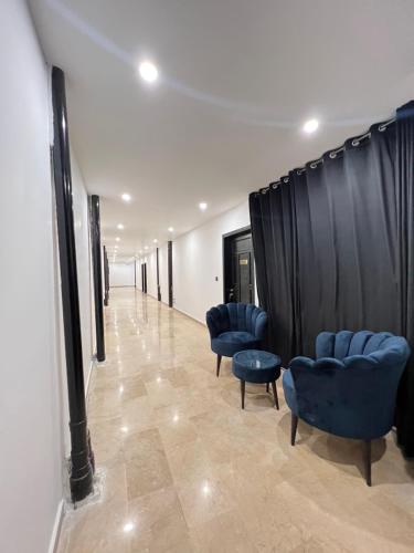 a corridor with blue chairs and a black curtain at BULAND HEIGHTS in Murree