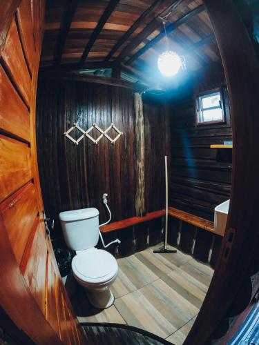 a bathroom with a toilet in a wooden cabin at Chalé da Árvore Cotijuba COP 30 in Belém