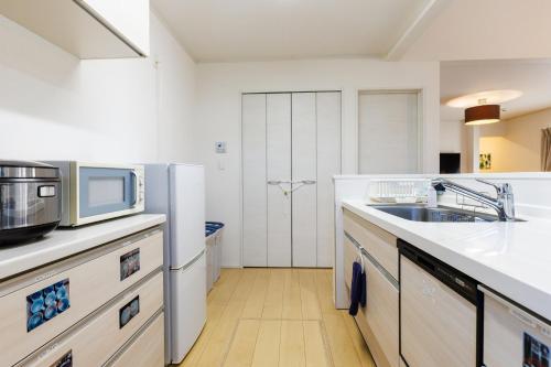 a kitchen with a sink and a microwave at BBQ可能 美ら海水族館まで5分 最大11名宿泊可能　Emerald Side3 in Urasaki