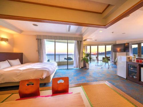 a bedroom with a bed and a kitchen with a view at Hotel Resonex Nago in Nago