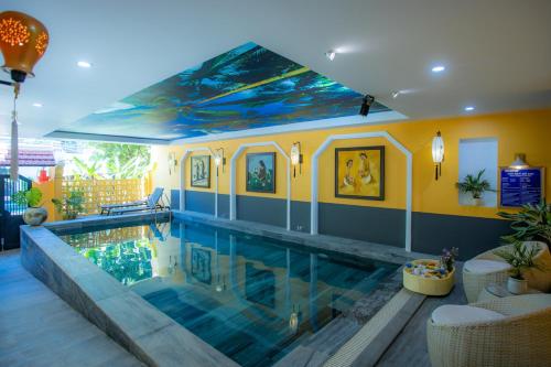 a swimming pool in a house with a painting on the ceiling at Hoianan Boutique Hotel in Hoi An