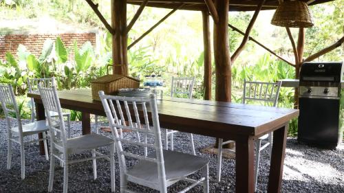 einen Holztisch und Stühle unter einem Zelt in der Unterkunft Uma Villa Manado in Manado