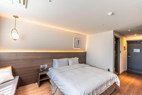 a bedroom with a large white bed in it at Hotel The Grang Jungmun in Seogwipo