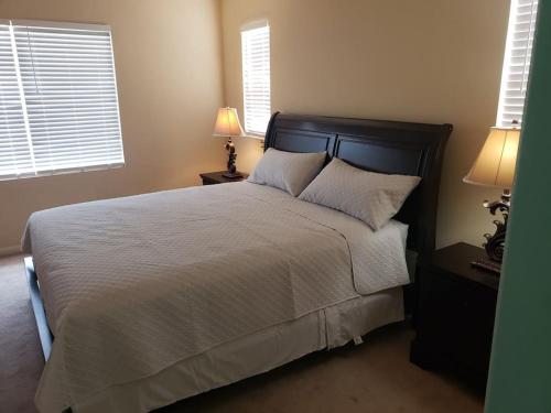 sypialnia z łóżkiem z 2 lampami i 2 oknami w obiekcie GREAT VACATION HOME IN TRACY w mieście Tracy