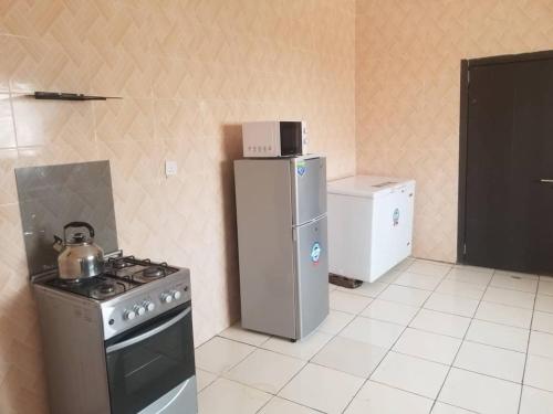 a kitchen with a stove and a refrigerator at Well furnished and very spacious apartment in Wuye in Abuja