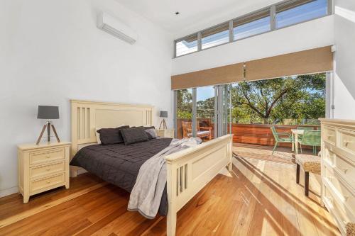 ein Schlafzimmer mit einem Bett und einem großen Fenster in der Unterkunft Orions Lookout Vincentia in Vincentia