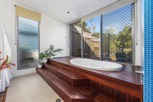 ein Badezimmer mit Badewanne und großem Fenster in der Unterkunft Orions Lookout Vincentia in Vincentia