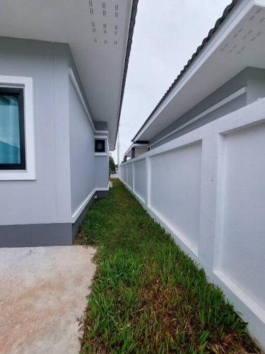 a corridor of a white building with a grass at We house - Hangdong1 in Hang Dong