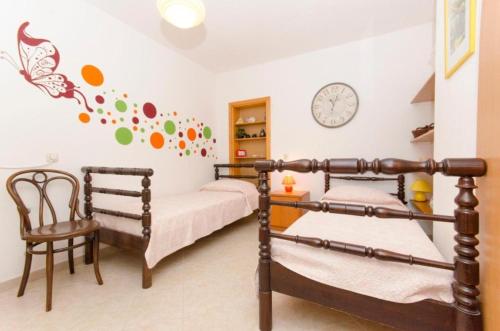 sypialnia z 2 łóżkami piętrowymi i zegarem na ścianie w obiekcie Villa Mate - with pool w Bol