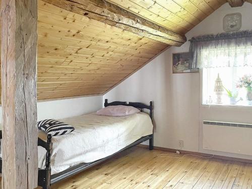 een bed in een kamer met een houten plafond bij Holiday home GÖTENE II in Götene