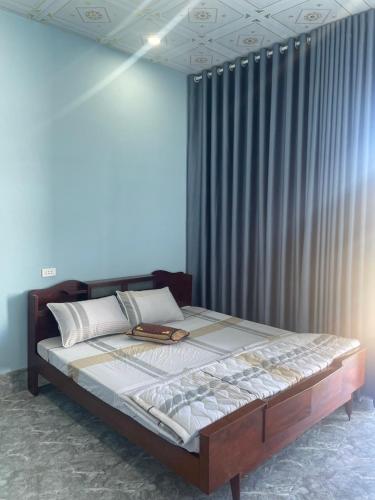 - un grand lit dans une chambre avec rideau dans l'établissement Nhà Nghỉ MoTel Thúy Linh, à Ấp Mỹ Hải
