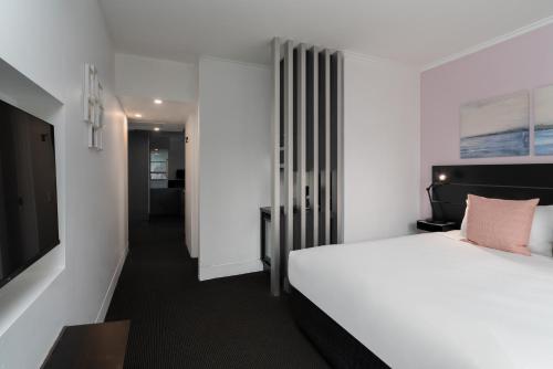 a hotel room with a bed and a tv at Park Regis City Centre in Sydney