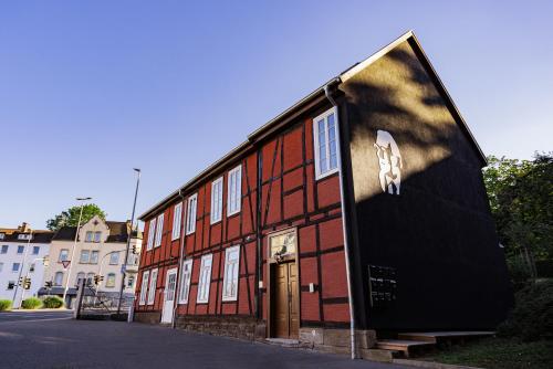 ein großes rotes Gebäude mit einem Schild an der Seite in der Unterkunft DWELLSTAY - Zuse Höfe Bad Hersfeld in Bad Hersfeld