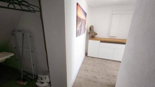 uma cozinha com armários brancos e um gato na parede em Hemma 4 U , 3 Zimmer Wohnung em Breiten