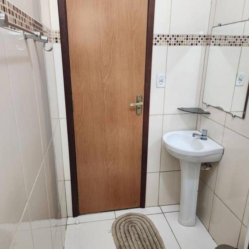 a bathroom with a toilet and a sink and a door at Casa Recanto de Unamar in Cabo Frio
