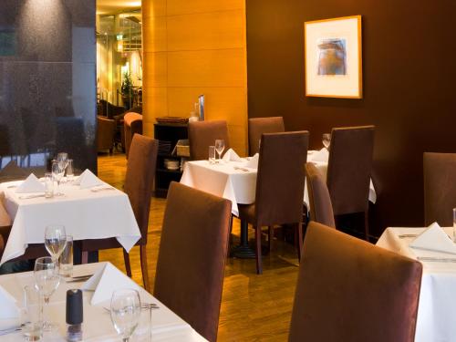 a dining room with white tables and chairs at Hotel Grand Chancellor Melbourne in Melbourne
