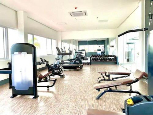a gym with several treadmills and machines in a room at The Hideaway at Citta Verde Primavera City in Cagayan de Oro